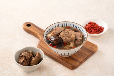 Lezzetli Tayvan şitaki mantarlı tavuk çorbası. Arka planda beyaz bir kasede..