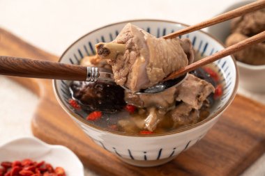 Lezzetli Tayvan şitaki mantarlı tavuk çorbası. Arka planda beyaz bir kasede..