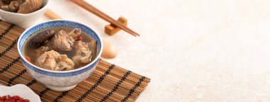 Lezzetli Tayvan şitaki mantarlı tavuk çorbası. Arka planda beyaz bir kasede..