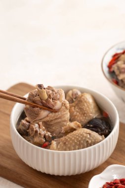 Lezzetli Tayvan şitaki mantarlı tavuk çorbası. Arka planda beyaz bir kasede..