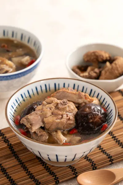 Lezzetli Tayvan şitaki mantarlı tavuk çorbası. Arka planda beyaz bir kasede..