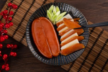 Delicious fresh mullet roe with white radish slices and garlic sprout for Chinese lunar new year gift basket box, holiday celebration.