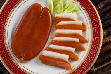 Delicious fresh mullet roe with white radish slices and garlic sprout for Chinese lunar new year gift basket box, holiday celebration.