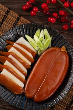 Delicious fresh mullet roe with white radish slices and garlic sprout for Chinese lunar new year gift basket box, holiday celebration.