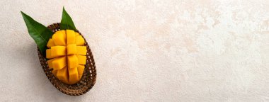 Taze dilimlenmiş, kesilmiş, dilimlenmiş, olgun mango gri masa zemininde yemek için yaprak ile birlikte..