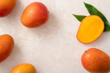 Taze dilimlenmiş, kesilmiş, dilimlenmiş, olgun mango gri masa zemininde yemek için yaprak ile birlikte..
