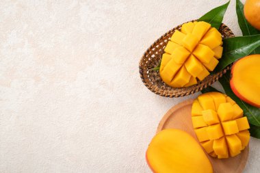 Taze dilimlenmiş, kesilmiş, dilimlenmiş, olgun mango gri masa zemininde yemek için yaprak ile birlikte..