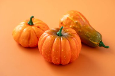 Hasat ve sonbahar Cadılar Bayramı için turuncu masa zemininde balkabakları, Şükran Günü tasarımı konsepti.