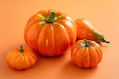 Hasat ve sonbahar Cadılar Bayramı için turuncu masa zemininde balkabakları, Şükran Günü tasarımı konsepti.