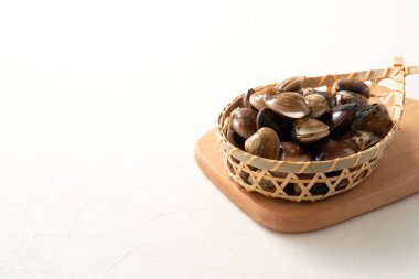 Çiğ ve taze midye kabuklu deniz ürünleri beyaz masa arkasında bir süzgeçte.