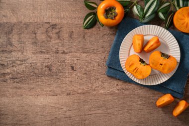 Tahta arka planda taze olgun hurma meyvesi..