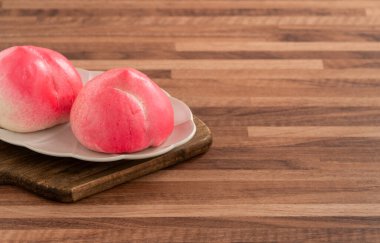 Pembe Çin şeftalili şeftalili doğum günü çöreği uzun ömürlü şeftali shoutao ahşap masa arkasında.