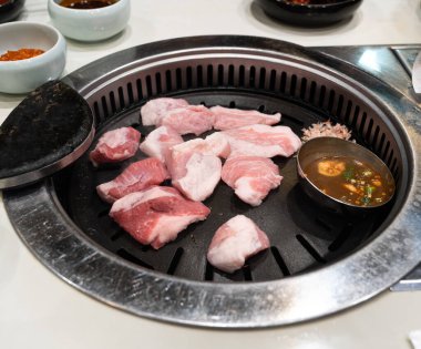 Kore restoranındaki demir mangal tahtasında domuz eti ızgara, taze lezzetli yemek mutfağı yaşam tarzı..