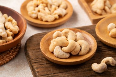 Beyaz masa arkasındaki kâselerde aromalı fındıklar..