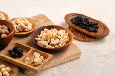 Beyaz masa arkasındaki kâselerde aromalı fındıklar..