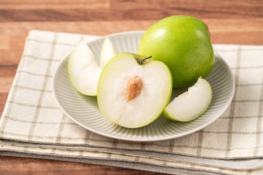 Tahta arka plandaki sepetin içinde taze sulu, lezzetli Tayvan Sütü Hint Jujube meyvesi..