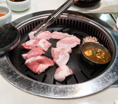 Kore restoranındaki demir mangal tahtasında domuz eti ızgara, taze lezzetli yemek mutfağı yaşam tarzı..