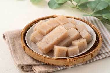 Japonya 'da Konnyaku olarak da adlandırılan beyaz masa arka planındaki bir tabakta kare şeklinde ham konjac.