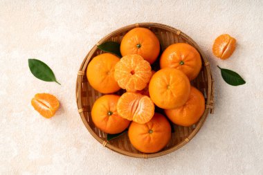 Beyaz masa arkaplanındaki tabakta taze mandalina portakalı..