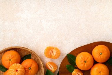 Beyaz masa arkaplanındaki tabakta taze mandalina portakalı..