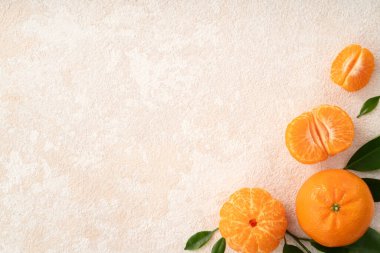 Beyaz masa arkaplanındaki tabakta taze mandalina portakalı..