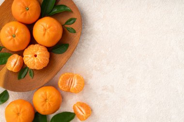 Beyaz masa arkaplanındaki tabakta taze mandalina portakalı..