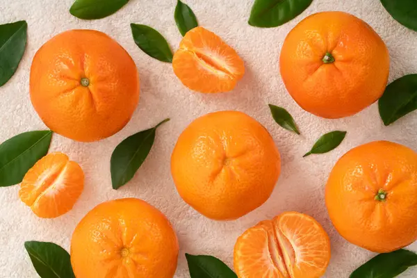 Beyaz masa arkaplanındaki tabakta taze mandalina portakalı..