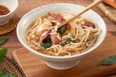 Geleneksel Tayvan kalamar çorbası, kalın çorba, ahşap masada seramik bir kasede servis edilir..