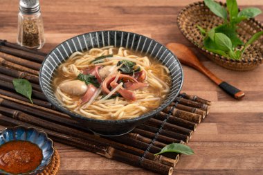 Geleneksel Tayvan kalamar çorbası, kalın çorba, ahşap masada seramik bir kasede servis edilir..