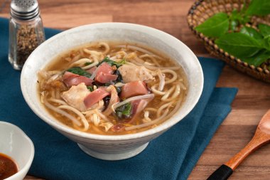 Geleneksel Tayvan kalamar çorbası, kalın çorba, ahşap masada seramik bir kasede servis edilir..