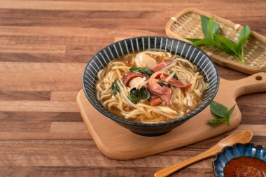 Geleneksel Tayvan kalamar çorbası, kalın çorba, ahşap masada seramik bir kasede servis edilir..