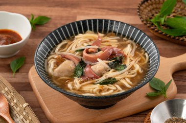 Geleneksel Tayvan kalamar çorbası, kalın çorba, ahşap masada seramik bir kasede servis edilir..