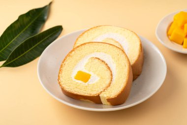 Lezzetli mango kremalı İsviçre usulü kek taze mango küpleriyle servis edilir..