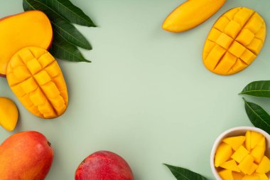 Sulu sarı mango küpleri ve yeşil masa arkaplanı.