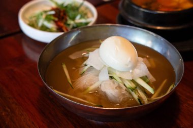 Soğutulmuş sebze ve haşlanmış yumurtayla servis edilen soğuk Kore eriştelerini tazeliyorum..