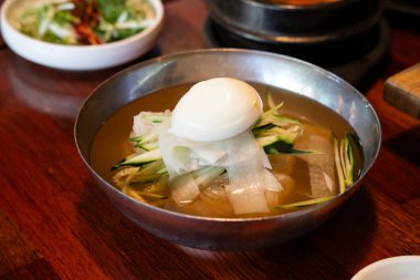 Soğutulmuş sebze ve haşlanmış yumurtayla servis edilen soğuk Kore eriştelerini tazeliyorum..