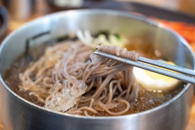 Soğutulmuş sebze ve haşlanmış yumurtayla servis edilen soğuk Kore eriştelerini tazeliyorum..