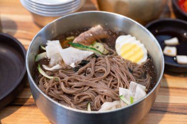 Soğutulmuş sebze ve haşlanmış yumurtayla servis edilen soğuk Kore eriştelerini tazeliyorum..