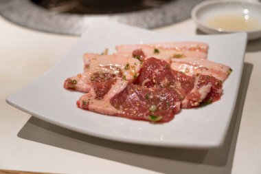 Barbekü restoranında marine edilmiş domuz eti dilimleri ızgara ediliyor..