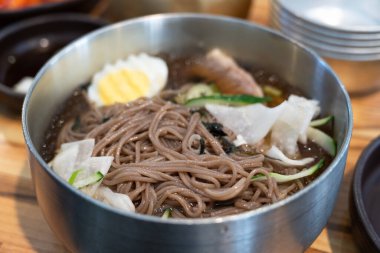 Soğutulmuş sebze ve haşlanmış yumurtayla servis edilen soğuk Kore eriştelerini tazeliyorum..