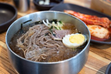 Soğutulmuş sebze ve haşlanmış yumurtayla servis edilen soğuk Kore eriştelerini tazeliyorum..