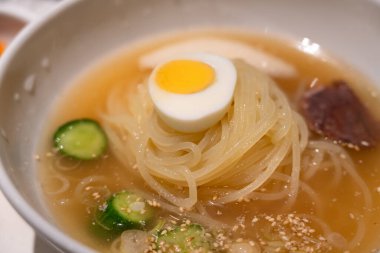 Soğutulmuş sebze ve haşlanmış yumurtayla servis edilen soğuk Kore eriştelerini tazeliyorum..