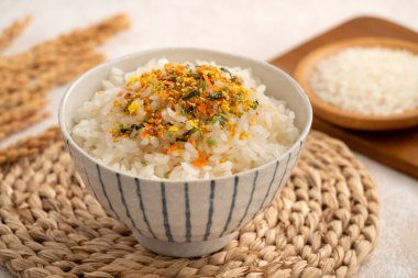 Üzerine pirinç baharatı serpiştirilmiş bir kase kabarık beyaz pirinç..