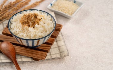 Üzerine pirinç baharatı serpiştirilmiş bir kase kabarık beyaz pirinç..