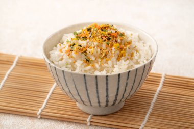 Üzerine pirinç baharatı serpiştirilmiş bir kase kabarık beyaz pirinç..