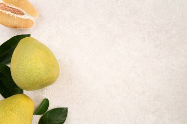 Güz ortası festivali meyveleri için beyaz masa zemininde yaprak kabuğu soyulmuş taze çiçek..