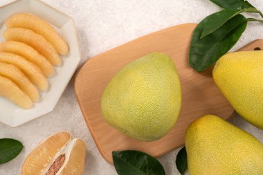 Güz ortası festivali meyveleri için beyaz masa zemininde yaprak kabuğu soyulmuş taze çiçek..