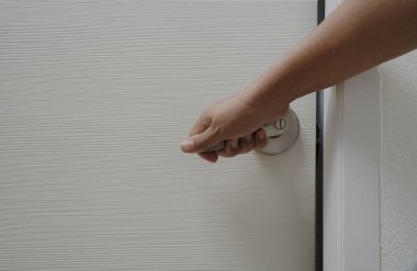 Beyaz kapıyı açmak için elini tut..