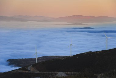 Gün batımında güzel bir manzarada dağdaki yel değirmeni.
