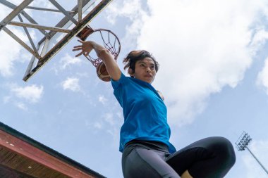 Denpasar, 13 Şubat 23: Endonezya 'nın Bali kentinde bir sokak basketbolu sahasında genç bir atlet smaç bastı.